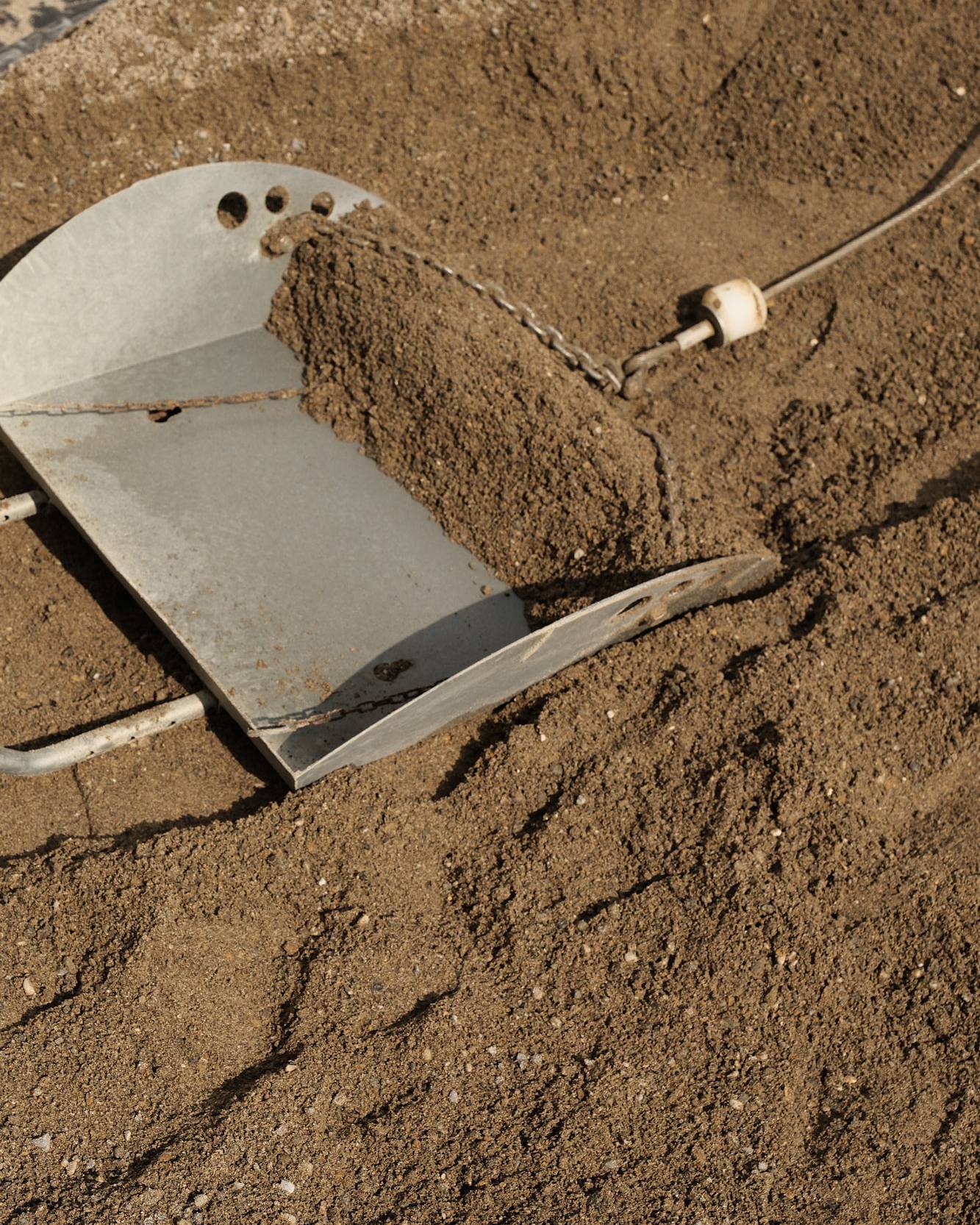 Nahaufnahme von einer Baustelle, wo gerade mit Sand gearbeitet wird.