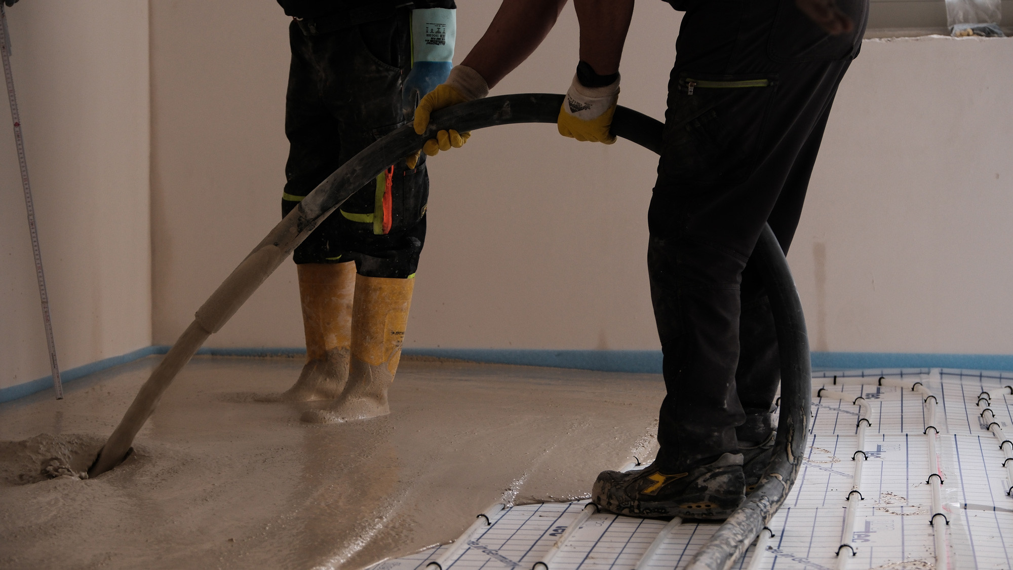2 Mitarbeiter bauen STANIplan in einem Mehrfamilienhaus auf Fu&szlig;bodenheizung, ein.