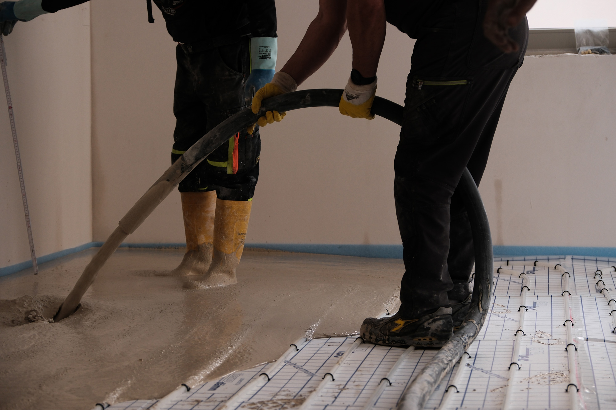 2 Mitarbeiter bauen STANIplan in einem Mehrfamilienhaus auf Fußbodenheizung, ein.
