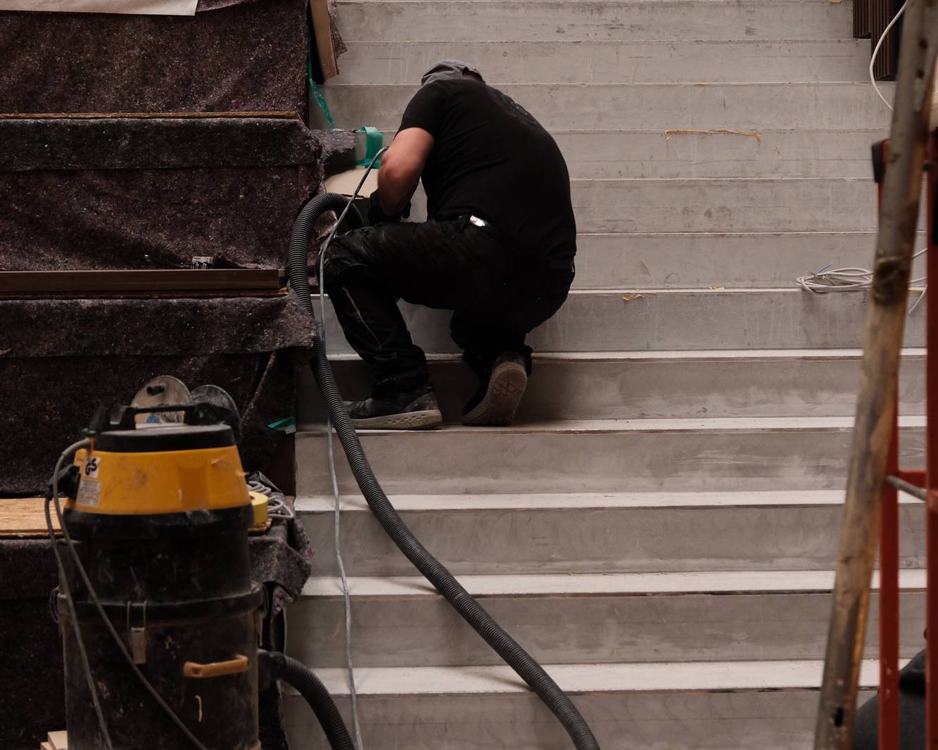 Mitarbeiter schleift eine Sichtestrichtreppe.