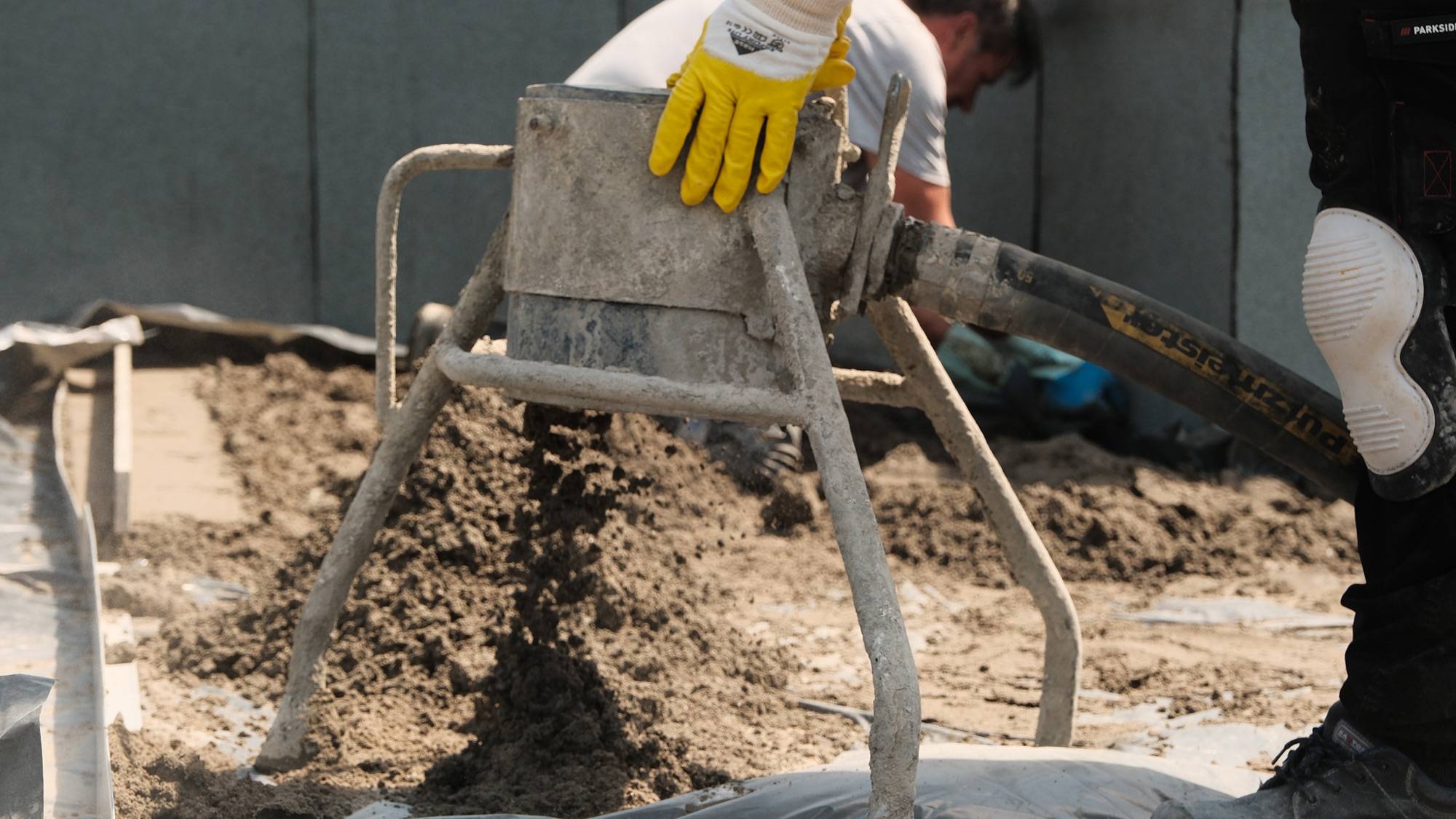 Einbau von Zementestrich auf einer Baustelle draußen.